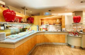 a restaurant kitchen with red food items on display at Leonardo Hotel Hannover Airport in Hannover