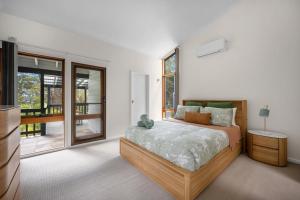 a bedroom with a bed with a teddy bear on it at Blenheim Beach Retreat in Vincentia