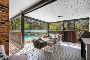 a patio with a table and chairs on a deck at Blenheim Beach Retreat in Vincentia