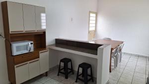 a kitchen with a sink and a counter with stools at Casa para 6 pessoas completa in Ribeirão Preto +8 photos