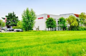 a large field of green grass in front of a building at Leonardo Hotel Heidelberg in Heidelberg