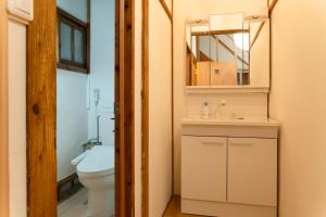 a bathroom with a toilet and a sink and a mirror at one space 泊まれるコワーキングスペース in Kawatana +36 photos