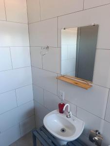 a white bathroom with a sink and a mirror at Rooftop BeiraMar in Balneario Barra do Sul