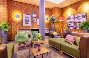 a lobby with couches and chairs in a room at Leonardo Hotel Wolfsburg City Center in Wolfsburg