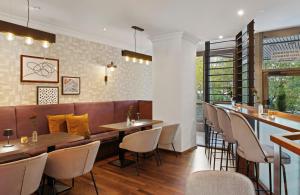 a restaurant with a bar and tables and chairs at Leonardo Royal Hotel Frankfurt in Frankfurt