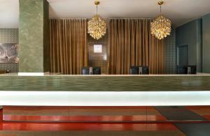 a lobby with a waiting area with chandeliers at Leonardo Hotel Berlin Mitte in Berlin +41 photos