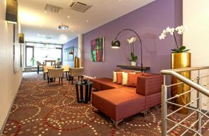 a living room with a couch and a table at Leonardo Hotel Munich City North in Munich