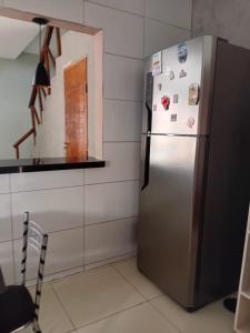 a stainless steel refrigerator in a kitchen next to a counter at Casa completa in Marechal Deodoro