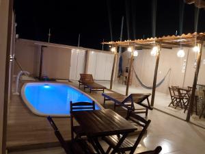 a large swimming pool with chairs and a table and a tablektop at Casa completa in Marechal Deodoro