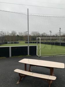 a wooden bench sitting in front of a tennis court at Charming, comfortable 3-room apartment in Ronchin