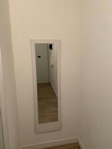 a mirror in a white room with a hallway at Charming, comfortable 3-room apartment in Ronchin