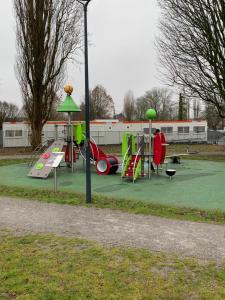 a playground with slides and play equipment in a park at Charming, comfortable 3-room apartment in Ronchin +13 photos