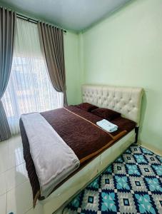 a small bed in a room with a window at Homestay Gavilla Dieng in Diyeng