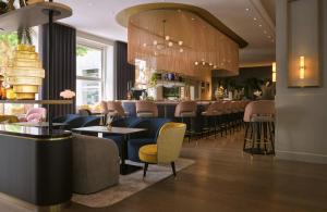 a restaurant with a bar with chairs and tables at Hotel Mannheimer Hof - Leonardo Limited Edition in Mannheim