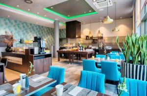 a restaurant with blue chairs and tables and a bar at Leonardo Royal Hotel Ulm in Ulm