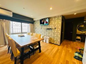 a dining room with a table and a tv on a wall at Vacances Skytree Plaza in Tokyo