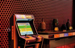 a video game machine in a room with a red wall at NYX Hotel Munich by Leonardo Hotels in Munich +49 photos
