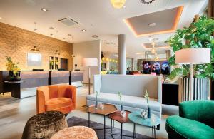 a lobby of a store with chairs and tables at Leonardo Royal Hotel Ulm in Ulm