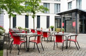 a row of tables and chairs in front of a building at Leonardo Hotel Dresden Altstadt in Dresden