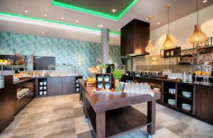 a large kitchen with a table with food on it at Leonardo Royal Hotel Ulm in Ulm +61 photos