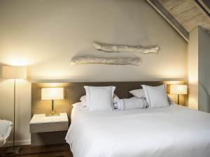 a bedroom with a large white bed with logs on the wall at Hotel Boutique Bovedas de Santa Clara By Accor in Cartagena de Indias