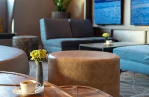 a living room with a table and a vase with flowers at Leonardo Hotel Munich City East in Munich +41 photos