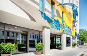 a building with a colorful mural on the side of it at NYX Hotel Munich by Leonardo Hotels in Munich