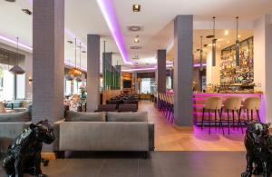 a lobby with couches and a bar with purple lighting at NYX Hotel Bilbao by Leonardo Hotels in Bilbao +73 photos