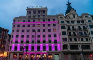 a building with purple lights on the side of it at NYX Hotel Bilbao by Leonardo Hotels in Bilbao