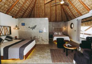 a bedroom with two beds and a couch and a table at Sicaru Mazunte in Mazunte