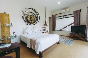 a bedroom with a large white bed and a tv at Sicaru Mazunte in Mazunte