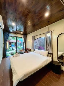 a bedroom with a large bed with a wooden ceiling at Pristine nature - Romantic - Green trees and lakes in Vũ Lâm +24 photos