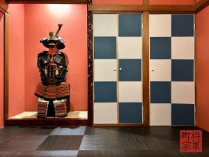 a statue of a samurai in a room with a wall at 将軍町家 in Nagoya