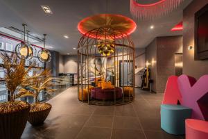 a lobby with a large cage with a couch in it at NYX Hotel Hamburg by Leonardo Hotels in Hamburg