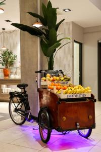 a bike with a cart full of oranges and bananas at Leonardo Royal Hotel Amsterdam in Amsterdam