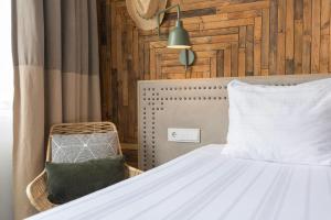 a bedroom with a white bed and a chair at Leonardo Hotel Vinkeveen Amsterdam in Vinkeveen