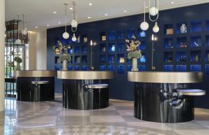 a lobby with blue walls and black and gold stools at The Posthouse Berlin Potsdamer Platz- Leonardo Limited Edition in Berlin