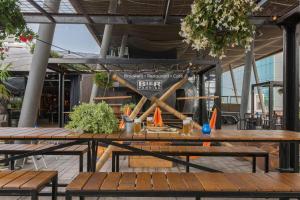 a group of wooden tables in a building at Leonardo Hotel Almere City Center in Almere
