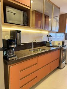 a kitchen with a sink and a microwave at Edifício Catamara in Vila Velha