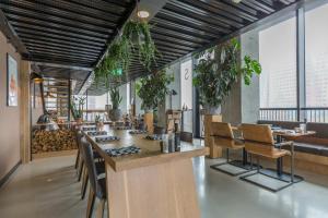 a restaurant with a bar with chairs and plants at Leonardo Hotel Groningen Stadspark in Groningen