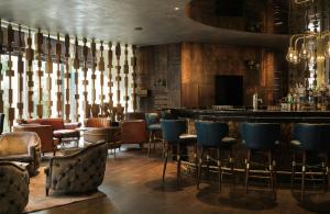 a bar at a restaurant with blue chairs at The Posthouse Berlin Potsdamer Platz- Leonardo Limited Edition in Berlin +46 photos