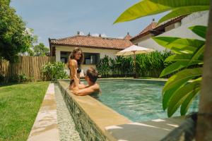 a woman and a boy in a swimming pool at The Confidential Mandalika - Sea Front Hotel - New Starlink 70Mbps WiFi - Free Gym Access in Kuta Lombok