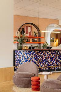 a living room with a chair and a mirror at Leonardo Hotel Groningen City Center in Groningen