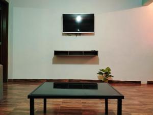 a living room with a table and a tv on a wall at La Casa de Lu cerca de Volcanic park in San Martín Ojo de Agua