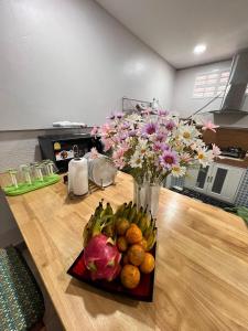 a vase filled with flowers and fruit on a table at 9 Home Phuket in Ban Rangeng
