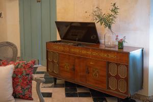 eine Holzkommode mit einem Fernseher darauf. in der Unterkunft Cien Sueños Hotel Boutique in Mérida