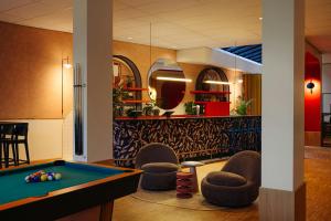 a billiard room with a pool table and chairs at Leonardo Hotel Groningen City Center in Groningen +44 photos