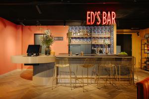 a bar in a restaurant with a bar stools at Leonardo Hotel Amsterdam Leidse Square in Amsterdam