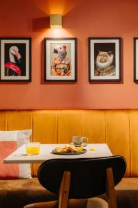 a table in a restaurant with pictures of cats on the wall at Leonardo Hotel Amsterdam Leidse Square in Amsterdam +27 photos