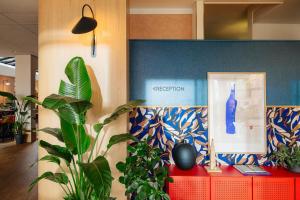 a room with a red table with a blue wall at Leonardo Hotel Groningen City Center in Groningen